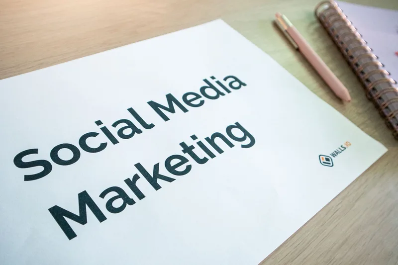 Social media content marketing strategy document on a desk alongside a pen and planning notebook