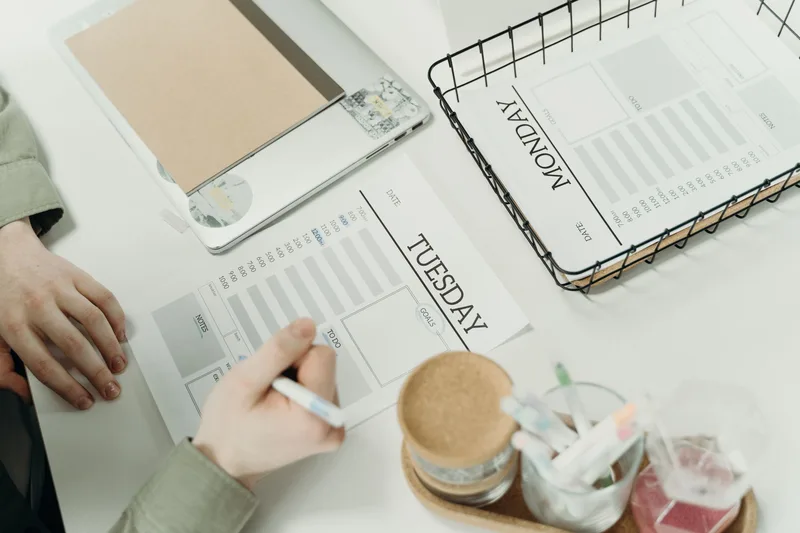 A professional organizing a weekly schedule with a detailed planner, representing how a freelance VA manages multiple clients