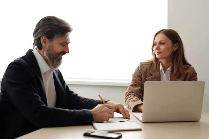 Employer writing a job description for a virtual assistant on a laptop