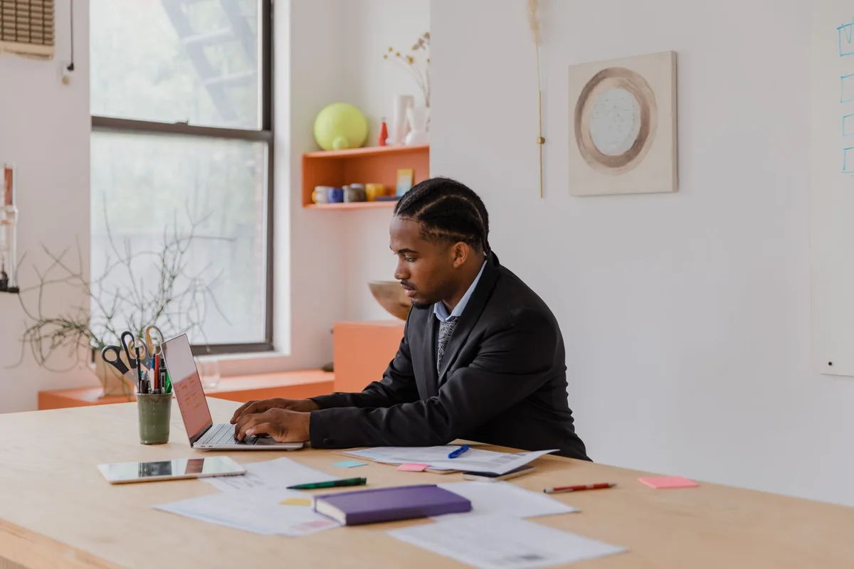 Business owner working on a laptop at a desk while planning to hire a virtual assistant