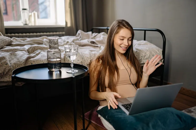Smiling virtual assistant on a video call with a client from her home workspace