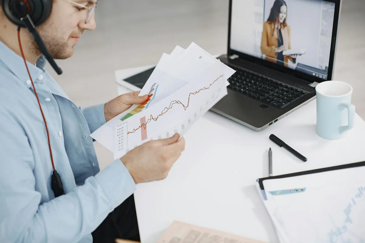 Ecommerce seller reviewing VA rates on a laptop with Philippine peso notes and a notepad on the desk