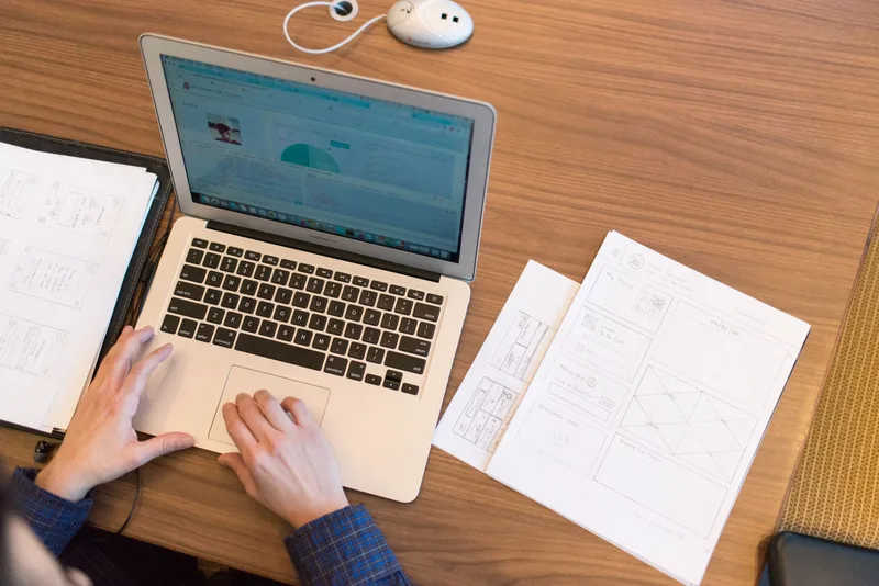 Overhead view of a laptop and desk workspace with documents