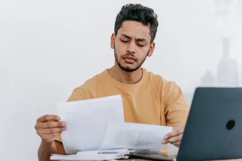 Remote worker reviewing application documents and job offers on a laptop