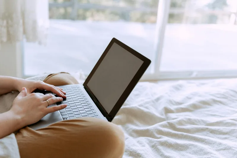 Person working on a laptop at a desk with product listings visible on the screen, showing different types of ecommerce VA work