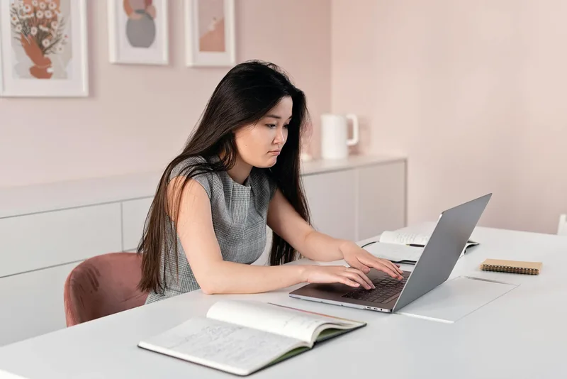Filipino virtual assistant preparing a work sample portfolio on a laptop at home