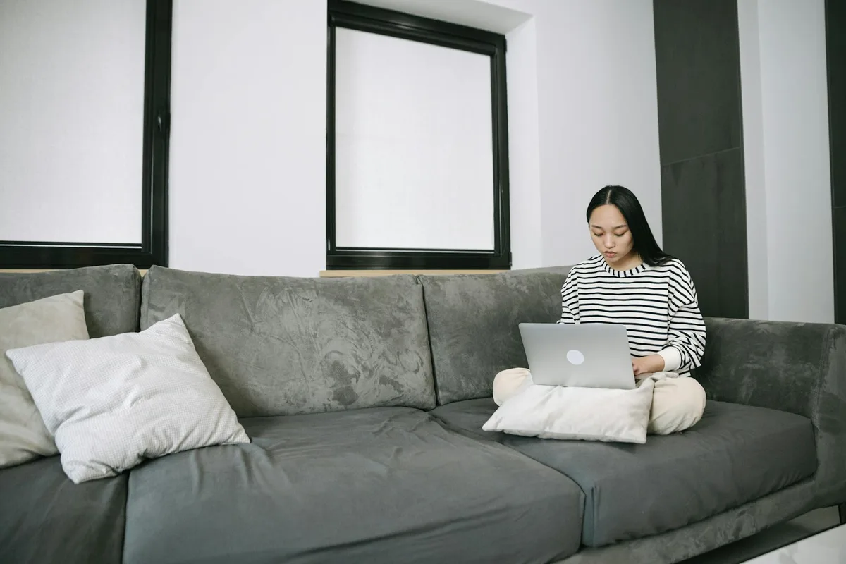 Filipino woman working as a part-time virtual assistant on her laptop at a home desk