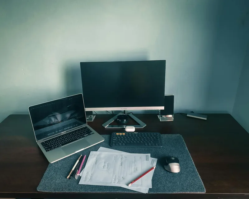 Filipino remote worker reviewing tasks at a desk with a clean laptop setup at home