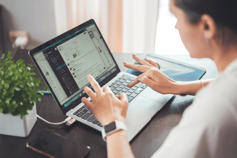 Woman working on a laptop from home, focused on remote task-based work